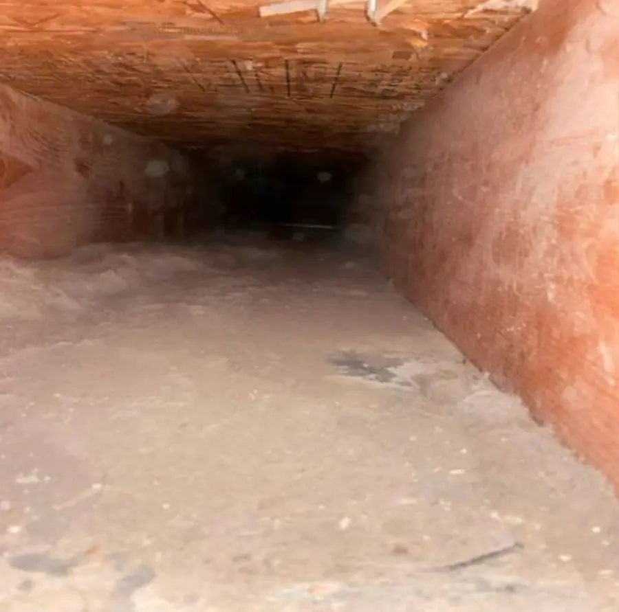 Dangerous Lint Buildup in Dryer Vent – Before Cleaning Thick layer of flammable lint accumulation inside a dryer vent duct located in a crawl space.